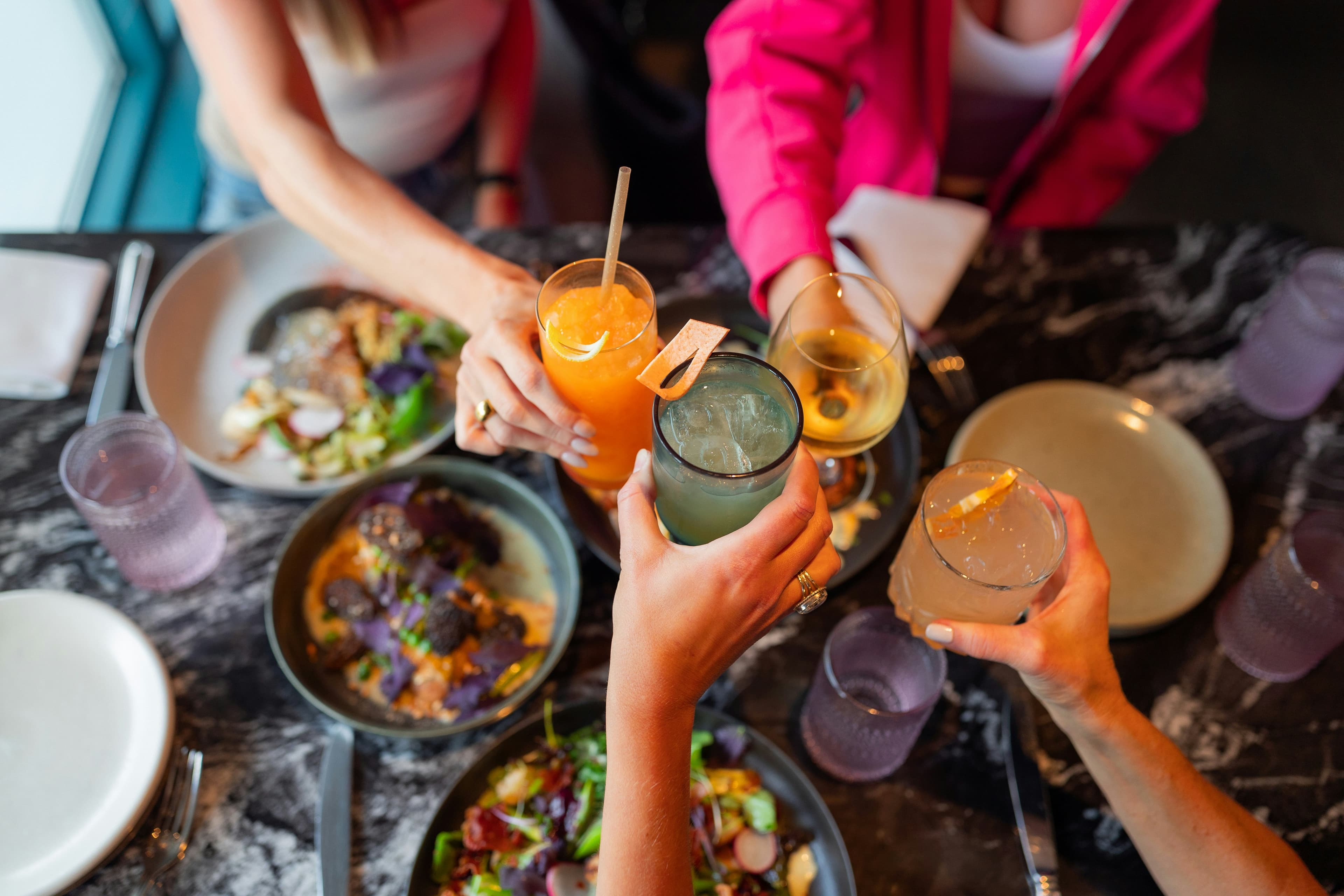 Mains levant des verres pour trinquer lors d'une soirée entre amis